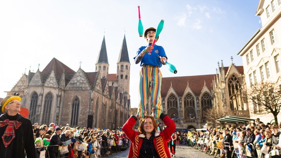 Eine mit Keulen jonglierende Karnevalistin nimmt am Karnevalsumzug Schoduvel teil. © Moritz Frankenberg/dpa Foto: Moritz Frankenberg/dpa