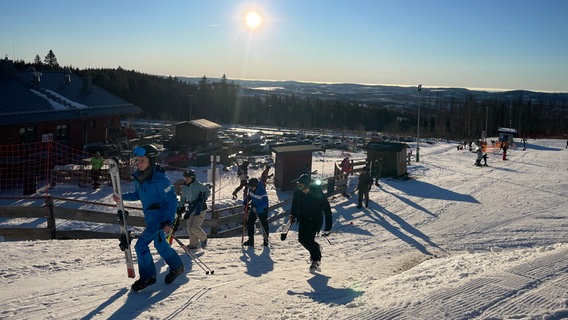 Personen gehen dem Wurmberg zum Skifahren hinauf. © NDR Foto: Lydia Callies