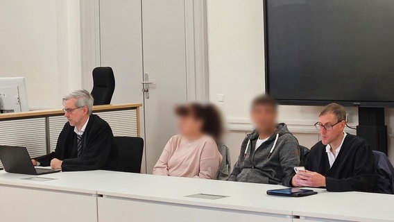 Zwei Verteidiger sitzen im Gerichtssaal mit dem angeklagten Ehepaar, das seine erwachsene Tochter und Stieftochter schwer sexuell missbraucht haben soll. © dpa Foto: Christian Brahmann