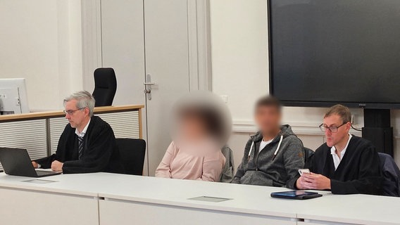 Zwei Verteidiger sitzen mit dem angeklagten Ehepaar, das seine erwachsene Tochter beziehungsweise Stieftochter schwer sexuell missbraucht haben soll im Gerichtssaal. © dpa Foto: Christian Brahmann