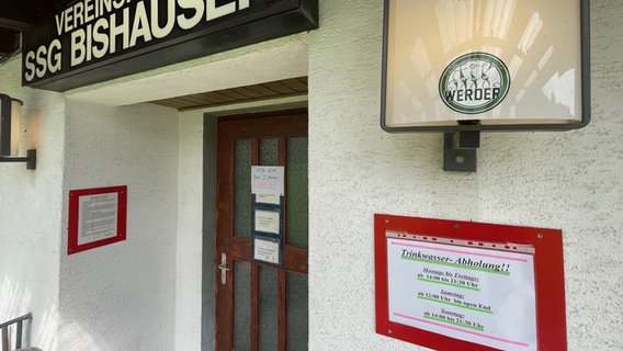 An der Tür zum Sportheim Bishausen stehen Zeiten für Trinkwasserabholung © NDR Foto: Jan Fragel