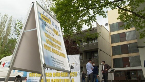 A display indicates a mobile Covid test center in a block of flats.  © NDR 