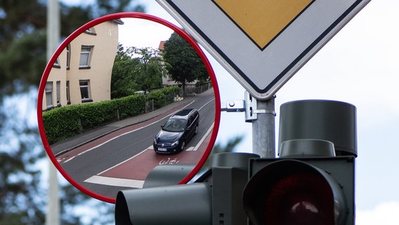 Ein Trixi-Spiegel für mehr Sicherheit im Straßenverkehr ist an einer Ampel befestigt. Die Verkehrsspiegel erweitern das Sichtfeld vor allem für LKW- und Busfahrer, wenn sie rechts abbiegen. © dpa-Bildfunk Foto: Swen Pförtner/dpa