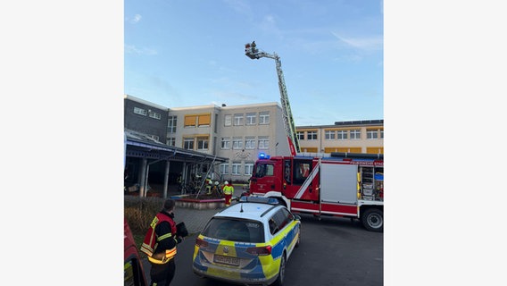 Einsatzkräfte der Feuerwehr stehen vor dem Gymnasium in Uslar. © Kreisfeuerwehr Northeim Foto: Oliver Sakel