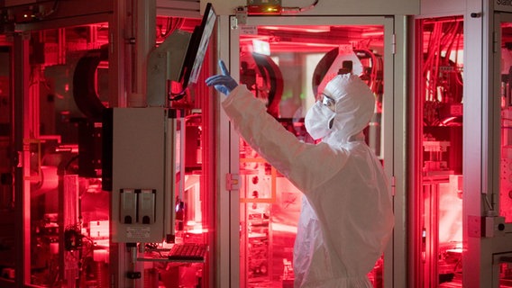 Ein Mitarbeiter von Volkswagen steht in einem Reinraum zur Produktion von Batteriezellen im VW Werk Salzgitter. © dpa Foto: Julian Stratenschulte