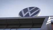 Das Logo von Volkswagen ist auf dem Dach eines Gebäudes zu sehen. © picture alliance/dpa Foto: Soeren Stache