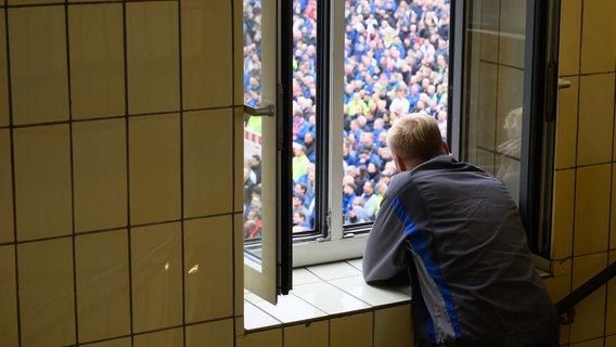 Ein VW-Mitarbeiter steht an einem Fenster und verfolgt eine Informationsveranstaltung des Gesamtbetriebsrates der Volkswagen AG im VW-Stammwerk Wolfsburg. © dpa-Bildfunk Foto: Julian Stratenschulte