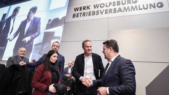 Die Vorsitzende des Gesamt- und Konzernbetriebsrats des Volkswagen-Konzerns Daniela Cavallo, Volkswagen-Chef Oliver Blume und der deutsche Arbeits- und Sozialminister Hubertus Heil (SPD) begrüßen sich vor einer Betriebsversammlung am Hauptsitz des Unternehmens in Wolfsburg. © dpa/AFP POOL Foto: Ronny Hartmann