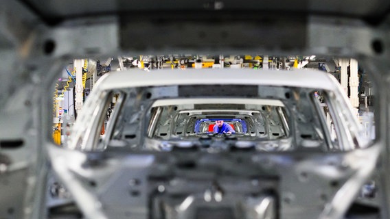 Wolfsburg: Ein Mitarbeiter schaut im VW Stammwerk im Karosseriebau durch Neuwagen Volkswagen Tayron und Tiguan. © dpa-Bildfunk Foto: Julian Stratenschulte