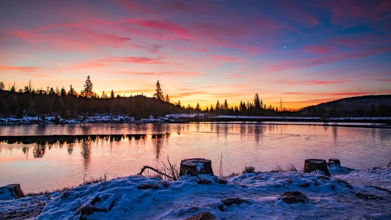 Die Sonne geht über dem verschneiten Oderteich auf. © NDR Foto: Jörg Baschin