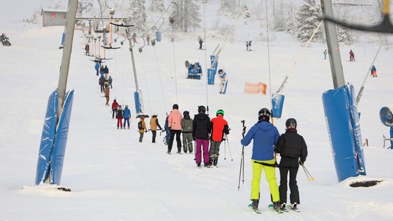 Wintersportler fahren mit dem Schlepplift am Wurmberg im Harz. © dpa Foto: Matthias Bein