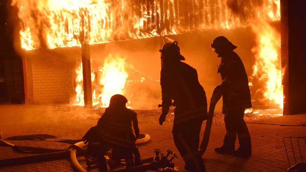 Feuerwehrleute löschen einen brennenden Carport in Wolfenbüttel.