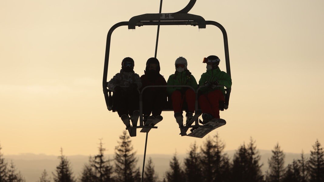 Skifahrer sitzen im Hexenritt-Sessellift am Wurmberg im Harz.