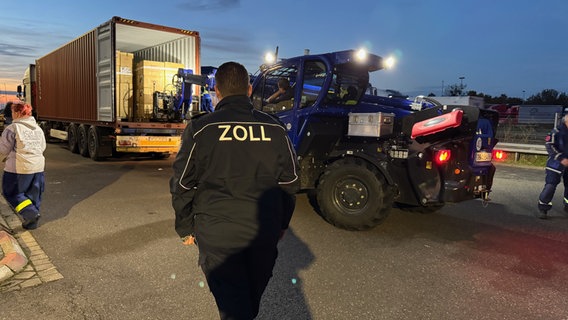 Ein Zoll-Beamter überwacht das Ausladen eines Containers, der auf einem Lkw geladen ist. © Zoll Foto: Zoll