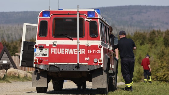 Einsatzkräfte der Feuerwehr beobachten vom niedersächsischen Wurmberg aus das Waldbrandgebiet am Brocken. © dpa-Bildfunk Foto: Matthias Bein/dpa