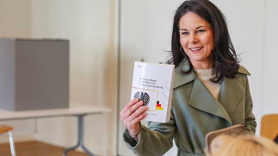 Außenministerin Annalena Baerbock (Bündnis 90/Die Grünen) hat in Potsdam ihre Stimme zur Bundestagswahl abgegeben. Sie hält das Buch "Rechtsgrundlagen für die Wahl zum 21. Deutschen Bundestag" in der Hand. © Jan Woitas/dpa Foto: Jan Woitas/dpa