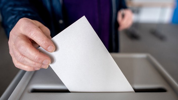 Ein Wähler wirft in Damme (Landkreis Vechta) in einem Wahllokal seinen Stimmzettel für die Bundestagswahl in eine Wahlurne. © dpa Foto: Hauke-Christian Dittrich/dpa