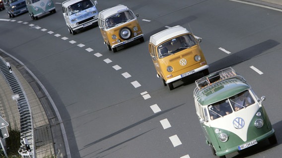 Das Bild zeigt mehrere Volkswagen Bullis die hintereinander eine Schnellstraße entlangfahren. © Volkswagen 