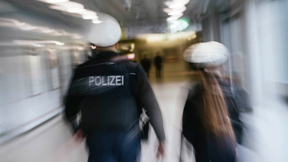 Zwei Beamte der Bundespolizei, in Bewegungsunschärfe fotografiert, laufen durch ein Flughafenterminal. © NDR Foto: Julius Matuschik