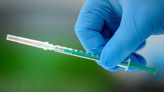 An employee holds a syringe in his hand at a vaccination center.  © picture alliance / dpa / Sina Schuldt Photo: Sina Schuldt