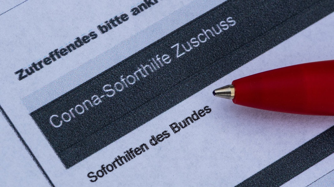 Ein Stift liegt auf einem Antrag für den Corona-Soforthilfe-Zuschuss.