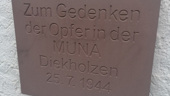 Auf einer Steintafel steht: Zum Gedenken der Opfer in der MUNA Diekholzen, 25.7.1944 © NDR Foto: Marc-Oliver Rehrmann