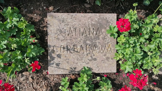 An den "Russengräbern" ist auf einer Steinplatte ein Name einer getöteten Zwangsarbeiterin aufgebracht. © NDR Foto: Marc-Oliver Rehrmann