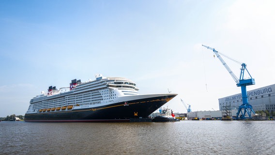 Papenburg: Das neugebaute Kreuzfahrtschiff "Disney Treasure" wird mit Schleppern von der Meyer Werft zur Schleuse gezogen. © picture alliance/dpa Foto: Sina Schuldt