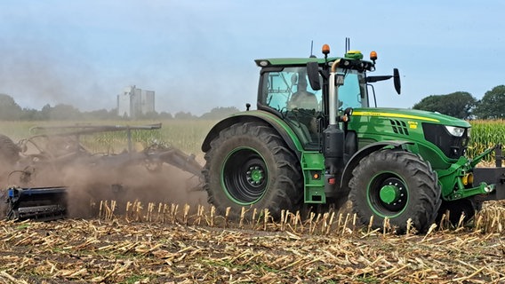 Ein Trecker fährt über Maisstoppeln auf einem Feld. © NDR Foto: Birgit Stramerjohanns