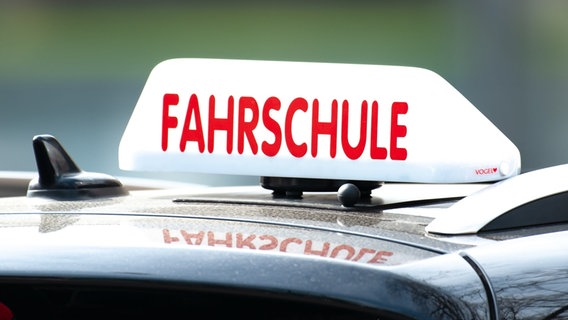 Ein Dachschild mit der Aufschrift "Fahrschule" ist auf einem Fahrschulauto befestigt. © picture alliance/dpa Foto: Swen Pförtner