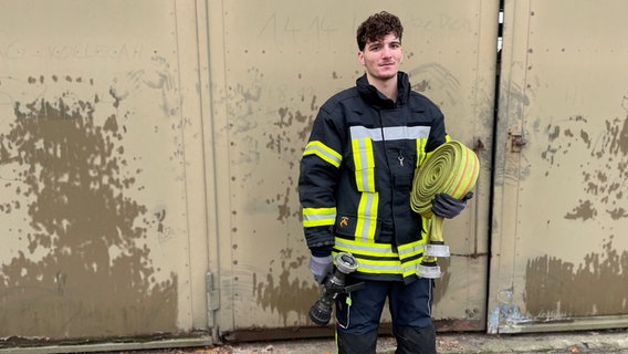 Abdelbasset Jened, 20 Jahre, aus Syrien, seit sieben Jahren in Deutschland, trägt eine Feuerwehr-Uniform. © NDR Foto: Catherine Grim