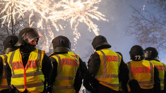 Mehrere Polizeibeamte beobachten ein Feuerwerk. © picture alliance/dpa | Clemens Heidrich Foto: Clemens Heidrich