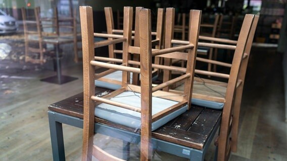 Stühle liegen umgedreht auf den Tischen eines geschlossenen Lokals. © dpa - Bildfunk Foto: Frank Rumpenhorst