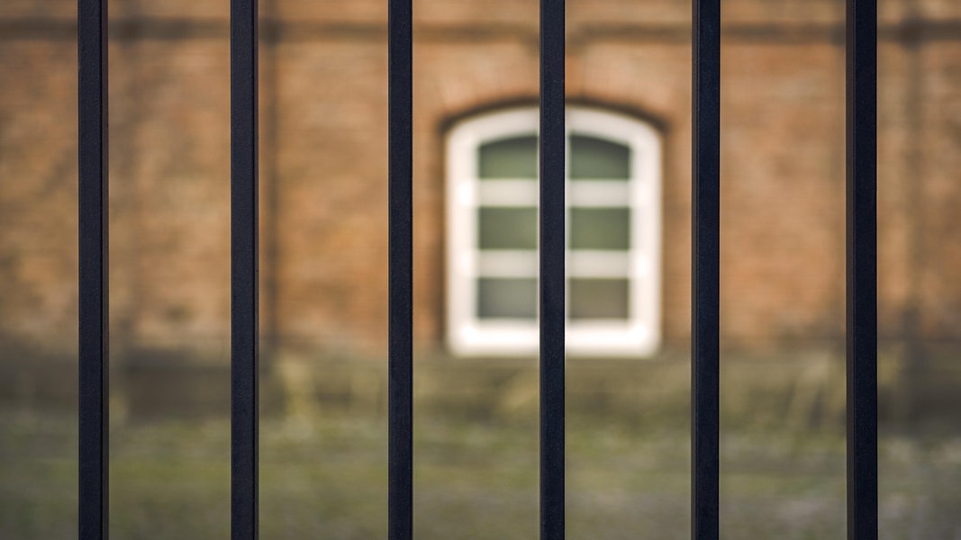 Blick aus einem Gefängnisfenster mit Gitterstäben.