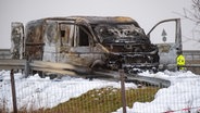 Ein ausgebrannter Geldtransporter steht nach einem Überfall an der Anschlussstelle Gützkow in Mecklenburg-Vorpommern. © picture alliance/dpa 