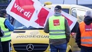 Teilnehmer eines Streiks stehen vor einer Niederlassung von Prosegur in Hamburg an einem Geldtransporter. © picture alliance/dpa Foto: Bodo Marks