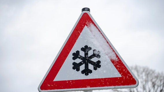 Warnschild, das vor Schnee und Glätte im Winter auf einer Landstraße warnt. © picture alliance / CHROMORANGE Foto: Michael Bihlmayer