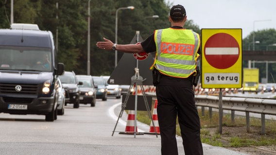 ARCHIV - Ein Beamter der Bundespolizei leitet am 01.07.2017 den Einreiseverkehr aus den Niederlanden auf der A30 bei Bad Bentheim zur Kontrolle über einen Parkplatz. © picture alliance / dpa Foto: Ingo Wagner