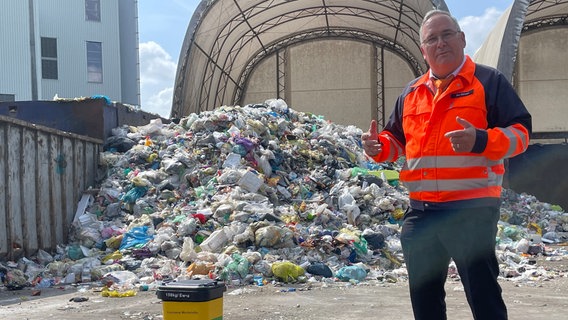 Thomas Schwarz, Geschäftsführer Abfallentsorger AHA, steht vor einem Müllberg. © NDR Foto: Niels Kristoph