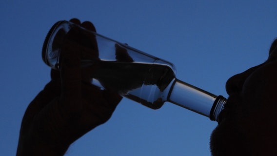 Ein Mann trinkt am Abend aus einer kleinen Flasche Schnaps. © picture alliance/dpa/dpa-Zentralbild Foto: Soeren Stache