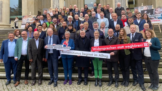 Viele Menschen stehen auf einer Treppe. Es werden auch Schilder hochgehalten. © NDR Foto: Amelia Wischnewski