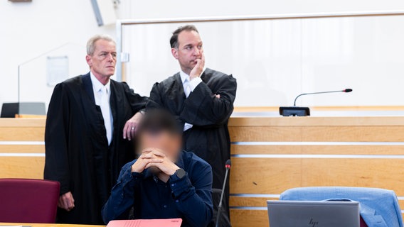 Der männliche Angeklagte (vorne) sitzt vor Verhandlungsbeginn in einem Gerichtssaal im Landgericht Hannover - im Hintergrund seine Anwälte. © Michael Matthey/dpa/ dpa-Bildfunk Foto: Michael Matthey/dpa