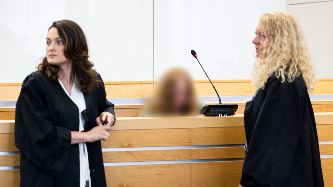 Der weibliche Angeklagte sitzt vor Verhandlungsbeginn in einem Gerichtssaal im Landgericht Hannover. Im Vordergrund sind ihre beiden Anwältinnen zu sehen.