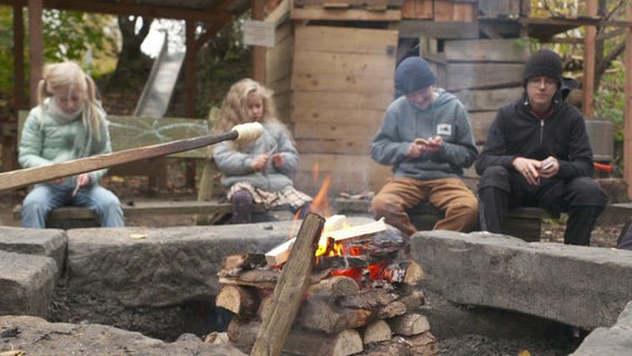 Kinder machen Stockbrot an einem Lagerfeuer. © NDR 