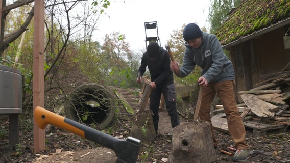 Zwei Kinder hacken Holz. © NDR 