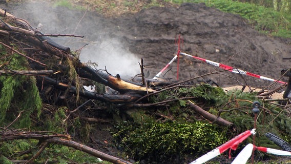 Bäume und Äste sind nach einem Osterfeuer in Beckedorf verkohlt. Hier war ein Baum im Osterfeuer umgestürzt. Eine Frau starb an ihren Verletzungen. © NDR 