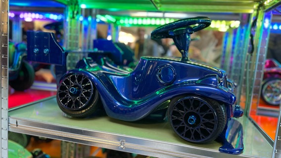 Ein lackiertes Bobbycar steht in einer Ausstellung. © NDR Foto: Barbara Kreuzer