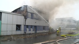 Die Feuerwehr löscht ein brennendes Gebäude.