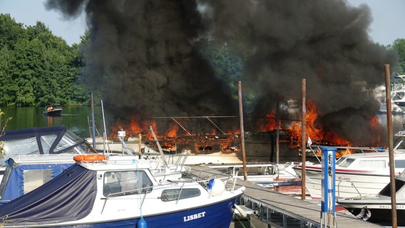 Flammen schlagen aus brennenden Booten im Sportboothafen Mehlbergen in Balge (Landkreis Nienburg). © Uwe Schiebe, Gemeindepressewart SG Weser-Aue 