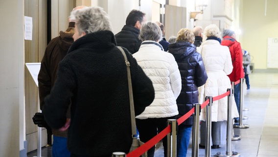 Wähler stehen Schlange für die Bundestagswahl 2025 in der Briefwahlstelle im Neuen Rathaus Hannover. © dpa-Bildfunk Foto: Julian Stratenschulte